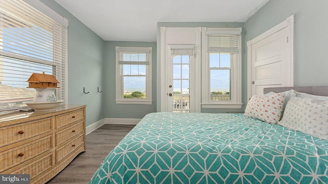 bedroom with dark wood-type flooring and access to outside