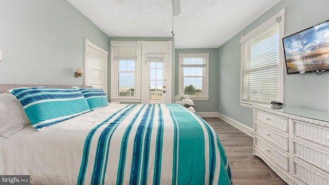 bedroom featuring ceiling fan, a textured ceiling, and dark hardwood / wood-style flooring