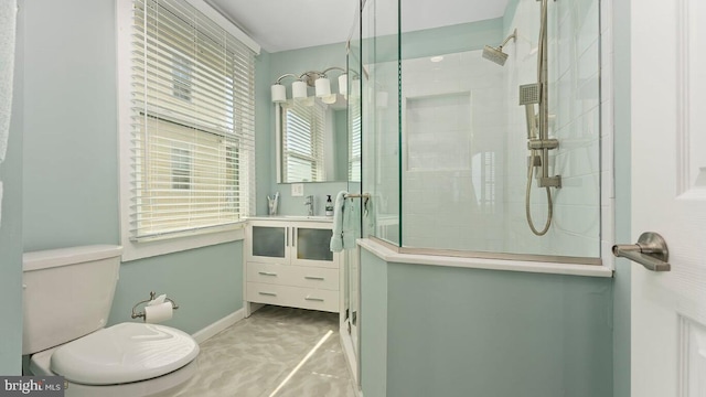 bathroom featuring vanity, tiled shower, and toilet