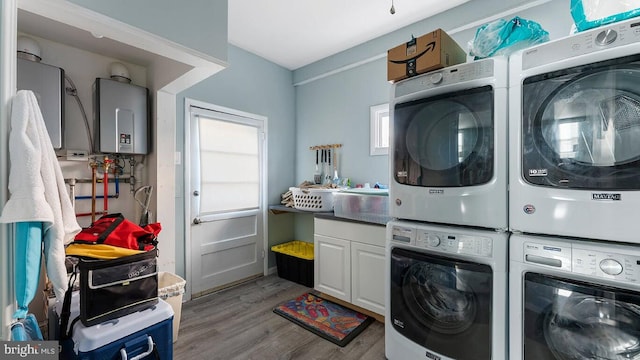 laundry room featuring washing machine and clothes dryer, stacked washer and clothes dryer, light hardwood / wood-style floors, and water heater