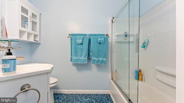 full bathroom featuring enclosed tub / shower combo, vanity, and toilet