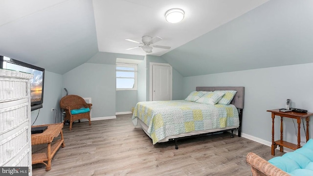 bedroom featuring ceiling fan, lofted ceiling, and light wood-type flooring