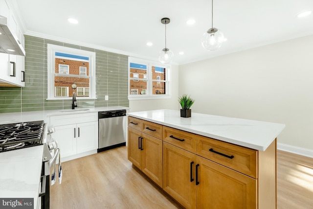 kitchen with a healthy amount of sunlight, ventilation hood, sink, appliances with stainless steel finishes, and a kitchen island