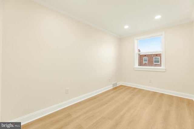 spare room featuring light hardwood / wood-style floors and ornamental molding