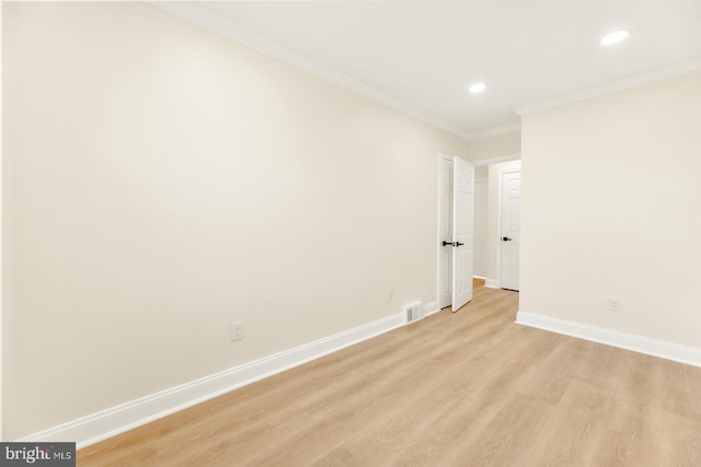 empty room featuring ornamental molding and light wood-type flooring