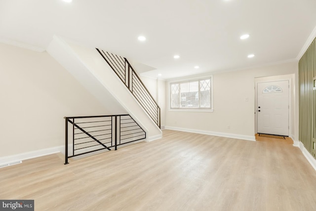 interior space with light hardwood / wood-style floors and crown molding