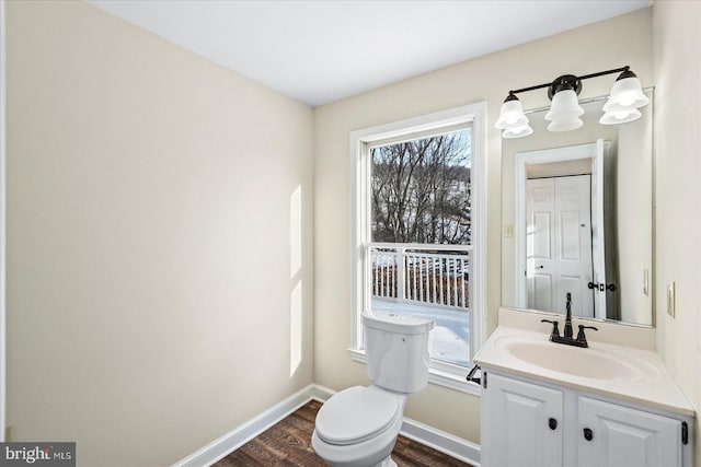 bathroom with vanity, toilet, and hardwood / wood-style floors