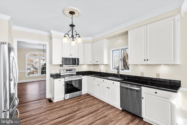 kitchen with sink, appliances with stainless steel finishes, white cabinetry, decorative light fixtures, and a chandelier