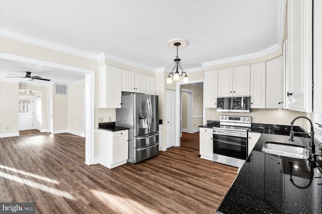 kitchen with sink, white cabinetry, appliances with stainless steel finishes, dark hardwood / wood-style floors, and pendant lighting