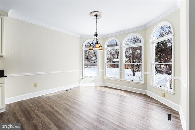 unfurnished dining area with ornamental molding, dark wood-type flooring, and a notable chandelier