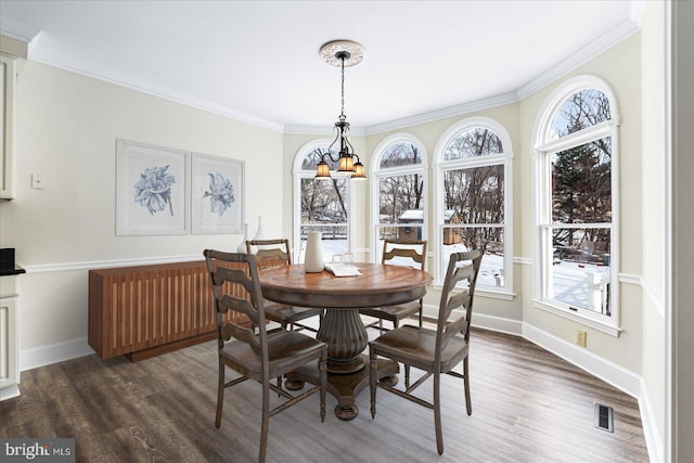 dining room featuring crown molding, dark hardwood / wood-style floors, and a notable chandelier