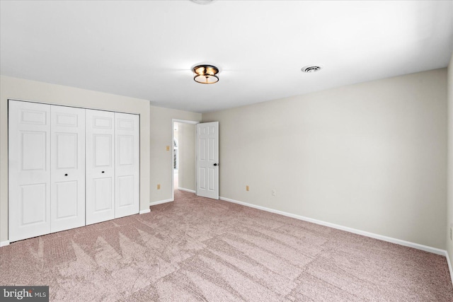 unfurnished bedroom featuring a closet and light carpet