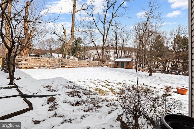 snowy yard featuring a shed