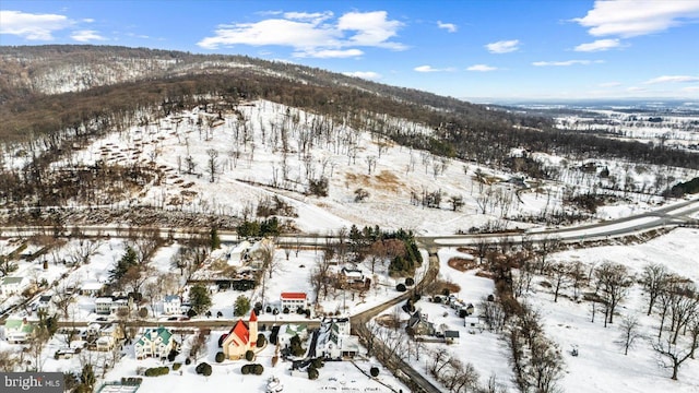 snowy aerial view featuring a mountain view