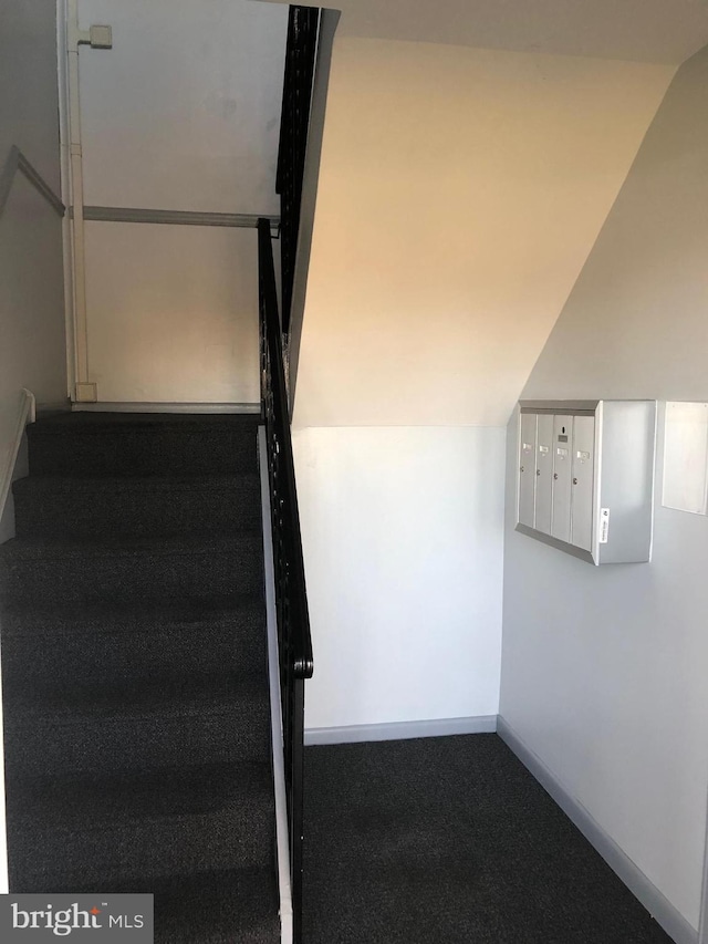 staircase featuring carpet flooring, mail boxes, and vaulted ceiling