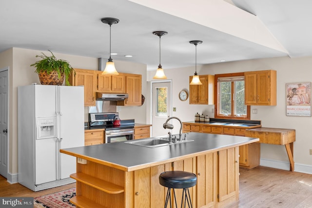 kitchen with electric range, sink, white refrigerator with ice dispenser, a kitchen island with sink, and light wood-type flooring