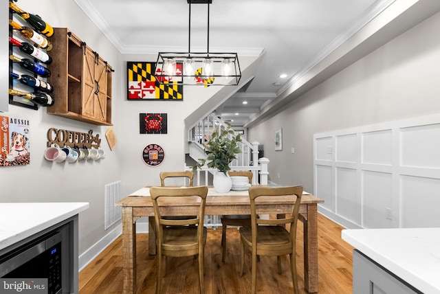 dining area featuring light hardwood / wood-style flooring and ornamental molding