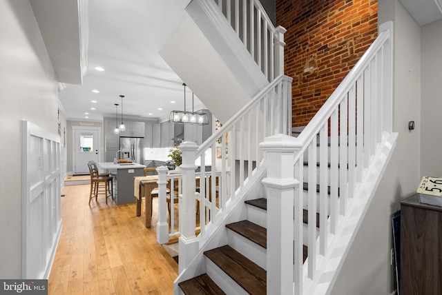 stairs with a chandelier and wood-type flooring