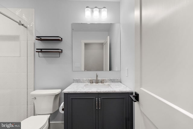 bathroom featuring vanity, toilet, and walk in shower