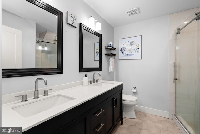 bathroom with tile patterned flooring, vanity, toilet, and walk in shower