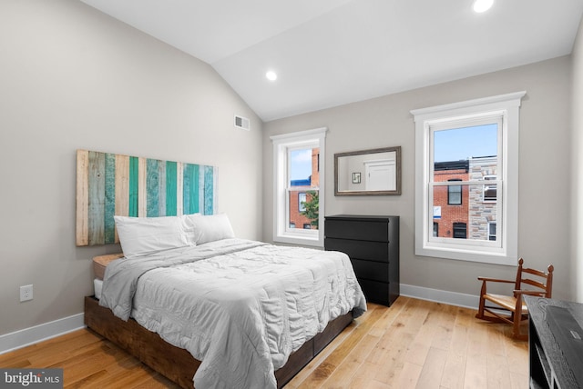 bedroom with multiple windows, light hardwood / wood-style floors, and lofted ceiling