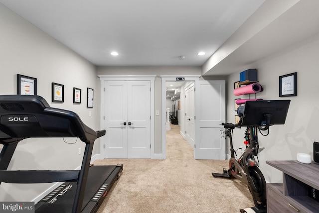 exercise room featuring light carpet