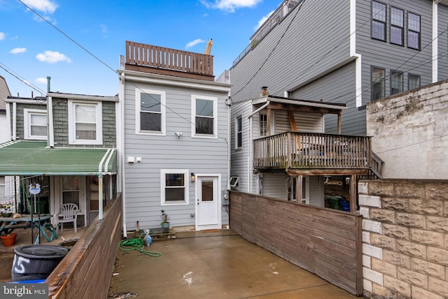 rear view of property with a patio and a balcony