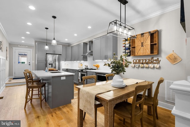 dining area with light hardwood / wood-style flooring and crown molding