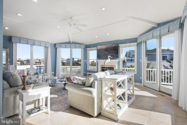 sunroom / solarium featuring plenty of natural light, ceiling fan, and lofted ceiling