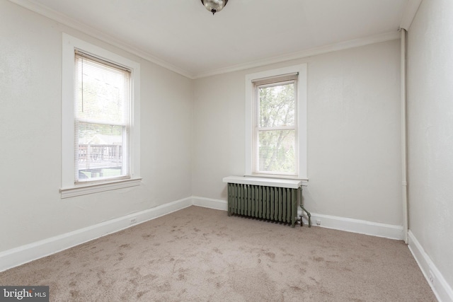 carpeted spare room with a wealth of natural light, radiator heating unit, and ornamental molding