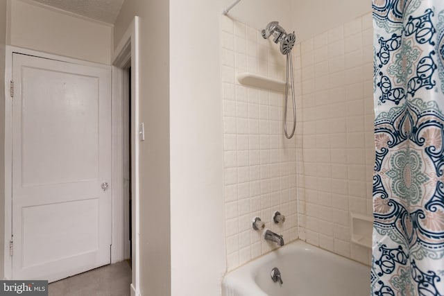 bathroom with shower / bath combo with shower curtain and a textured ceiling