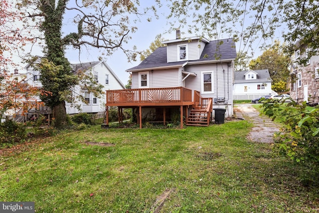 back of house with a lawn and a deck