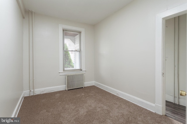 empty room with radiator heating unit and carpet floors