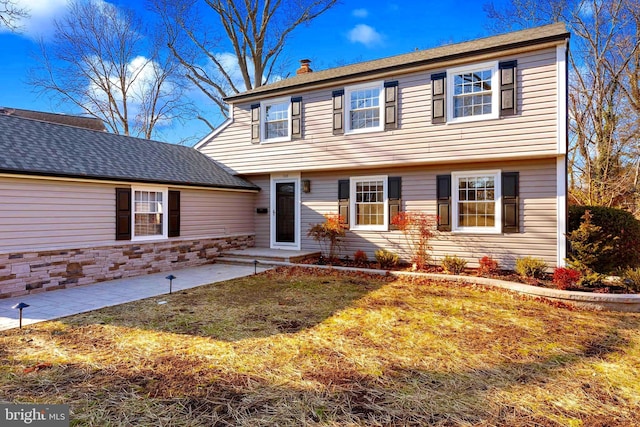 colonial inspired home with a patio area and a front yard