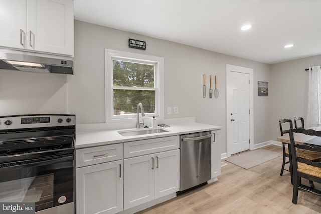 kitchen featuring sink, dishwasher, light hardwood / wood-style floors, white cabinets, and range