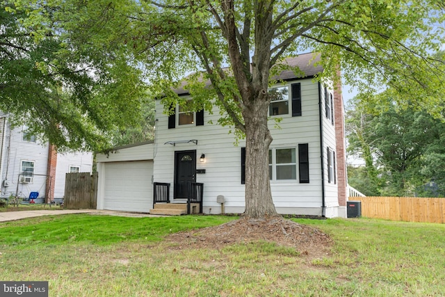 colonial-style house featuring cooling unit, a front yard, and a garage