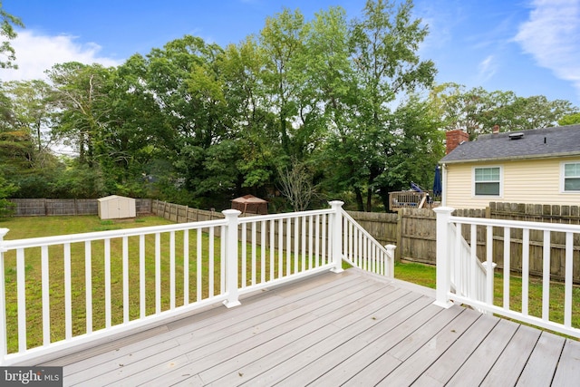 wooden deck with a yard and a storage unit