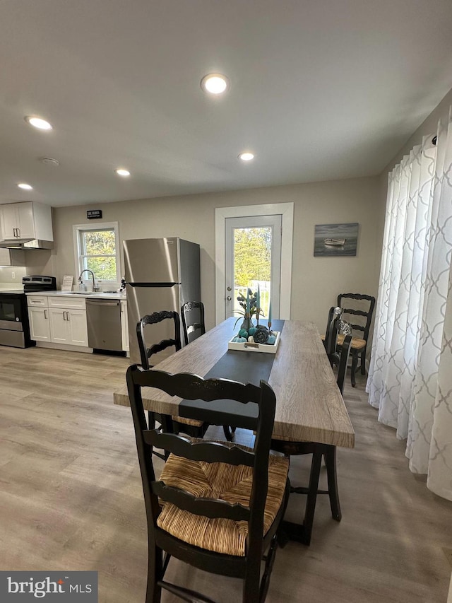 dining room with light hardwood / wood-style flooring and sink