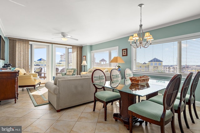 tiled dining area featuring a healthy amount of sunlight, ceiling fan with notable chandelier, and ornamental molding