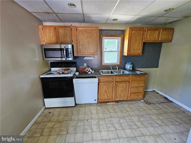 kitchen featuring sink, a drop ceiling, and white appliances