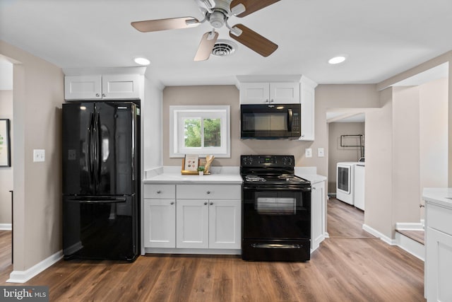 kitchen featuring dark wood-type flooring, white cabinetry, washer and clothes dryer, and black appliances