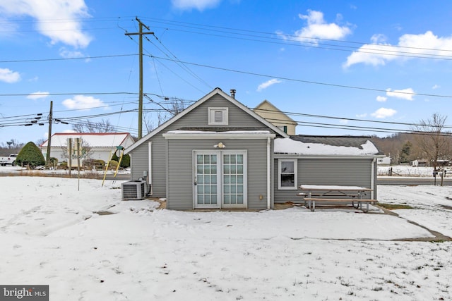 snow covered back of property with central air condition unit