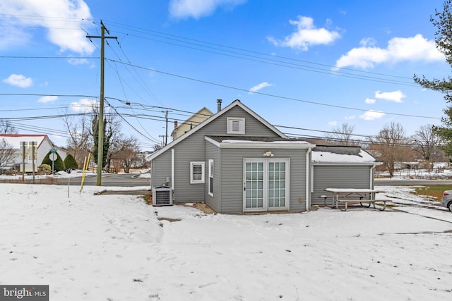 snow covered house with central AC unit