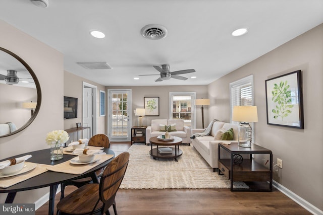 living room featuring ceiling fan and dark hardwood / wood-style flooring