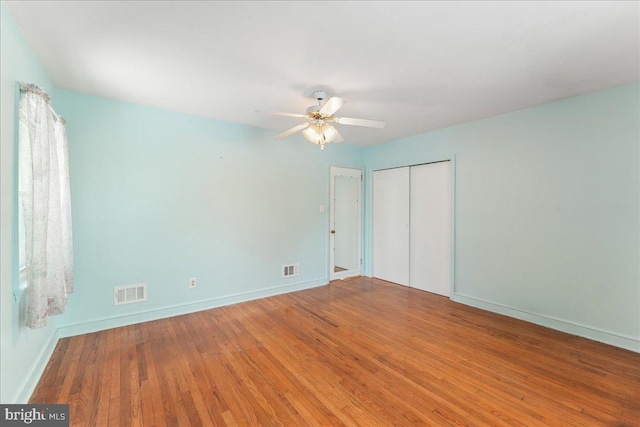 unfurnished bedroom featuring ceiling fan, wood-type flooring, and a closet