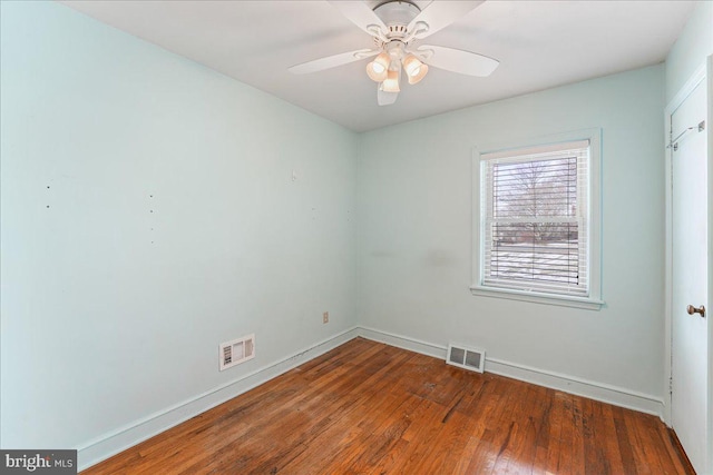 empty room with dark hardwood / wood-style floors and ceiling fan