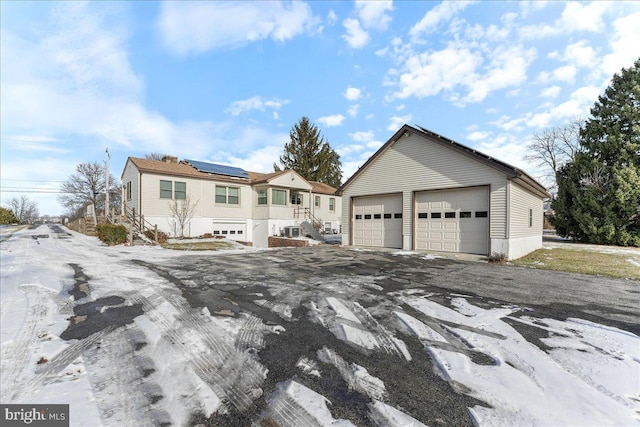 view of front facade featuring solar panels and a garage