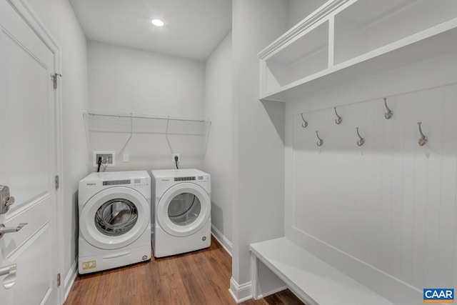 clothes washing area with separate washer and dryer and dark wood-type flooring