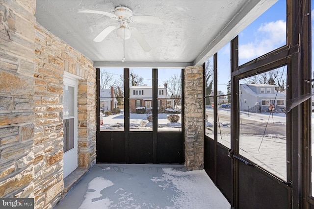 unfurnished sunroom with ceiling fan