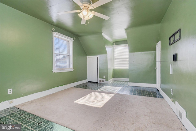 additional living space featuring carpet, a healthy amount of sunlight, lofted ceiling, and ceiling fan